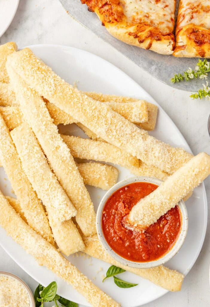 Serving platter of the crazy breadsticks with marinara sauce for dipping.