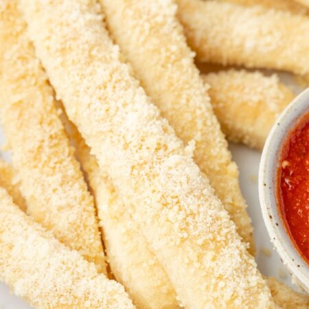 Crazy bread in a stack on a white serving plate.