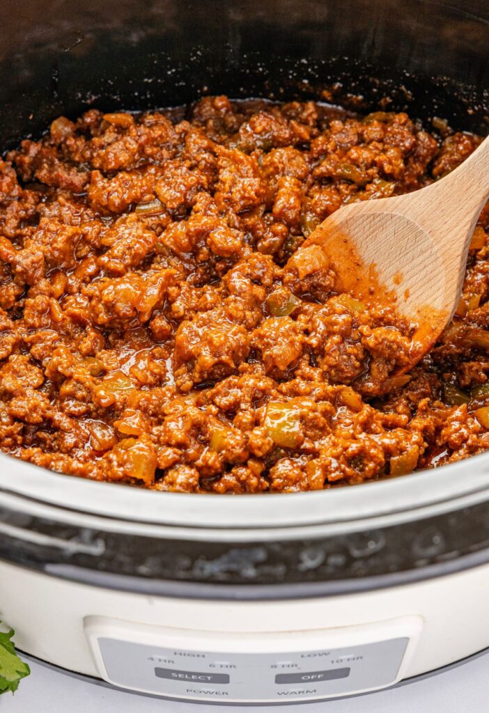 Inside of the crock pot with the cooked sloppy Joe meat mixture.