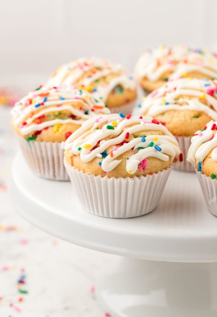 A white cake stand with funfetti muffins