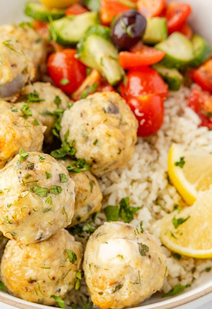 Greek meatballs with a greek salad in a rice bowl.