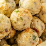 Close up of the cooked meatballs with greek flavors and a lemon wedge.