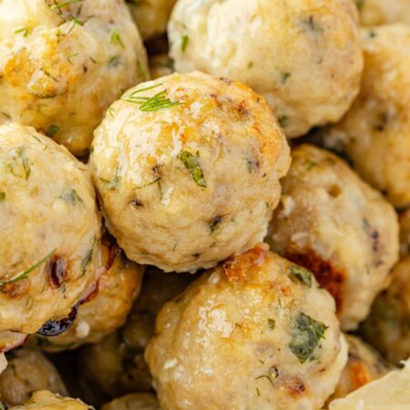 Close up of the cooked meatballs with greek flavors and a lemon wedge.