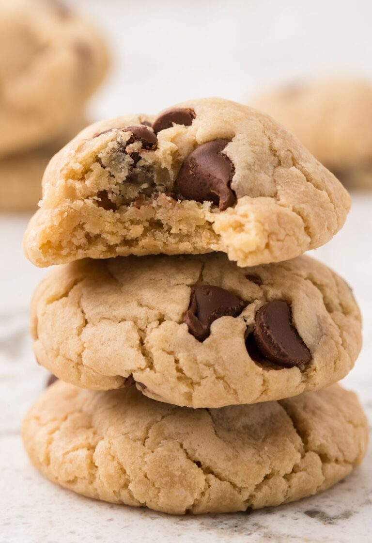 A stack of three eggless chocolate chip cookies with chocolate chips.