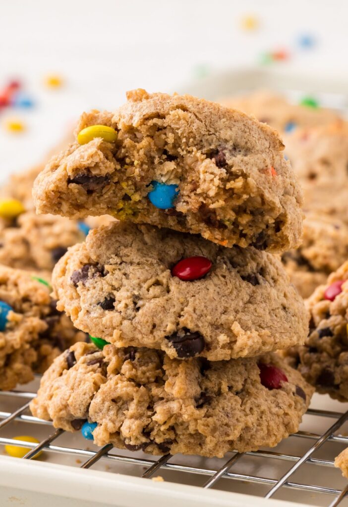 Stack of cookies on a cooling rack with the top having a bite taken out of it. 