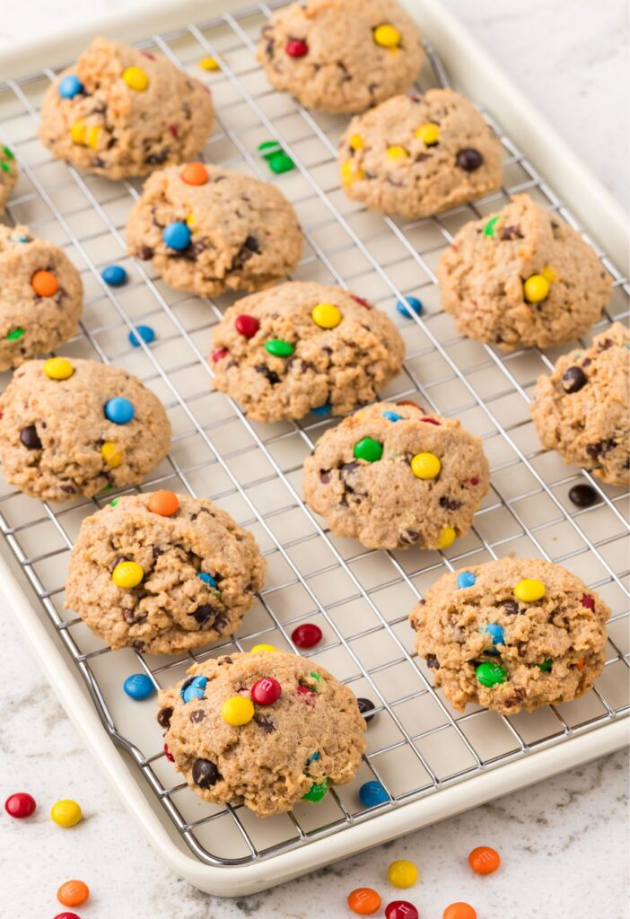 Cooling rack in the cookie sheet with monster cookies on it