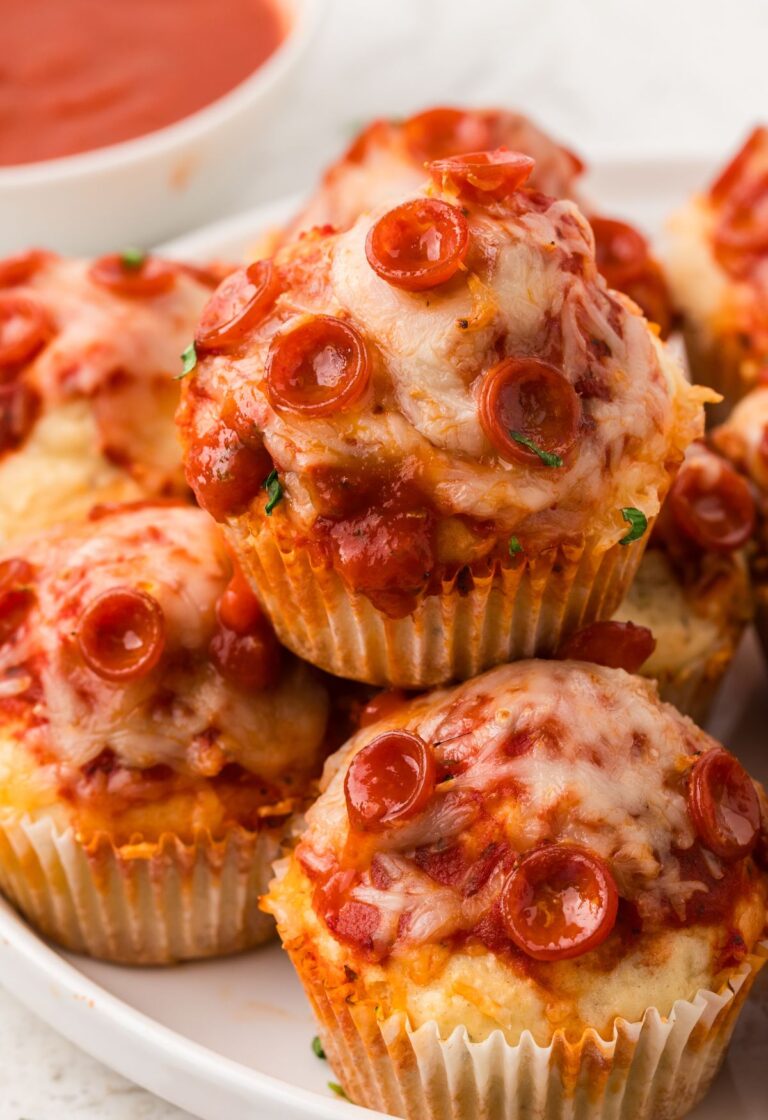 Pile of pizza muffins on a white plate with pepperoni.