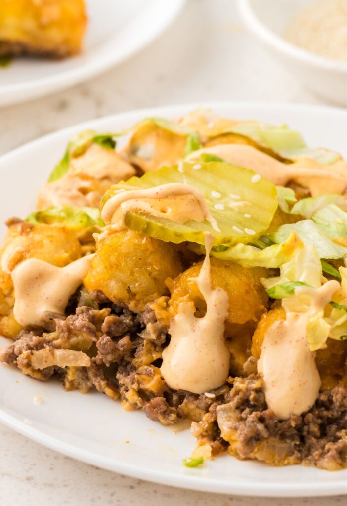 A serving of the Big Mac tater tot casserole on a white plate with a fork.