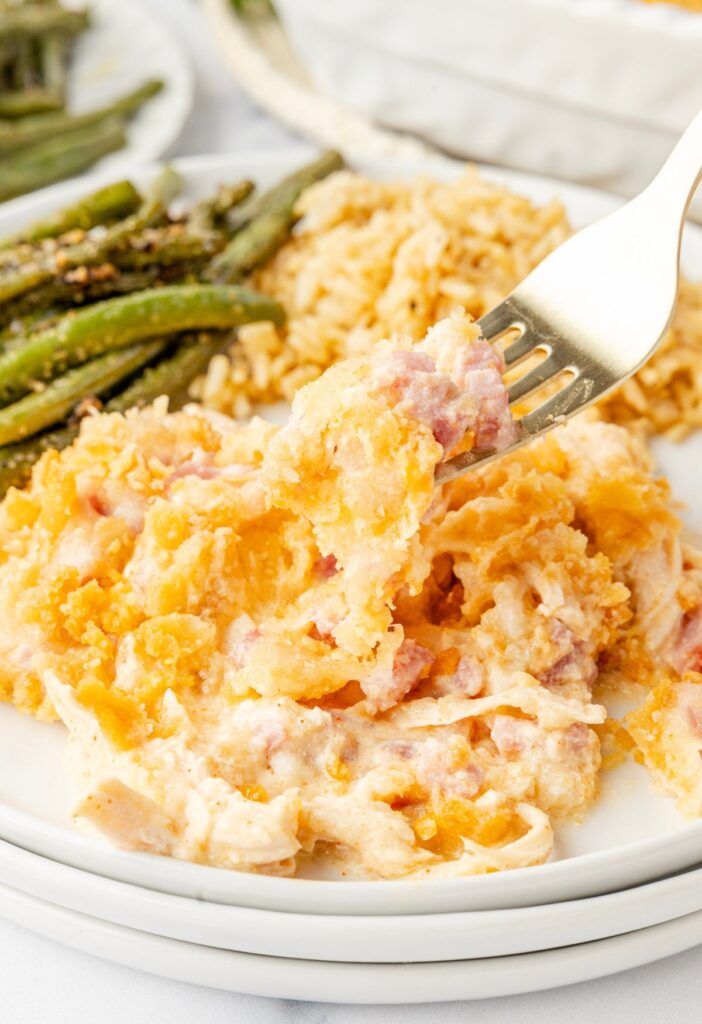 A white plate of the casserole with a fork picking some up.