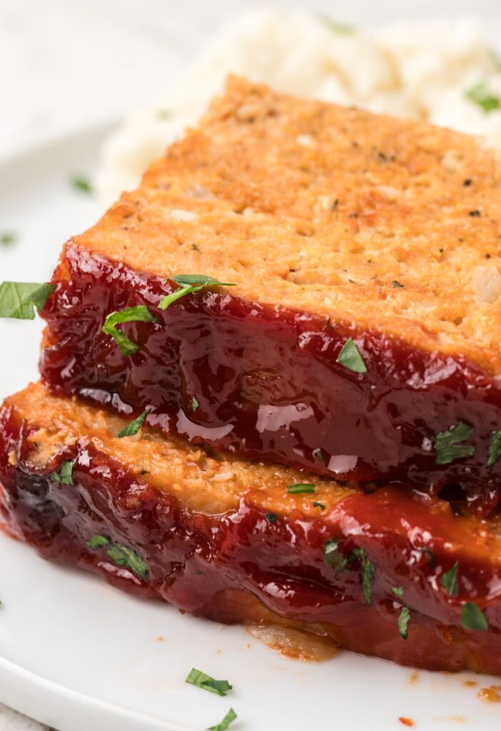 Side view of the glazed meatloaf on a white plate