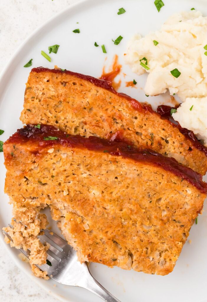 Slices of meatloaf with a fork taking some out of the slice.