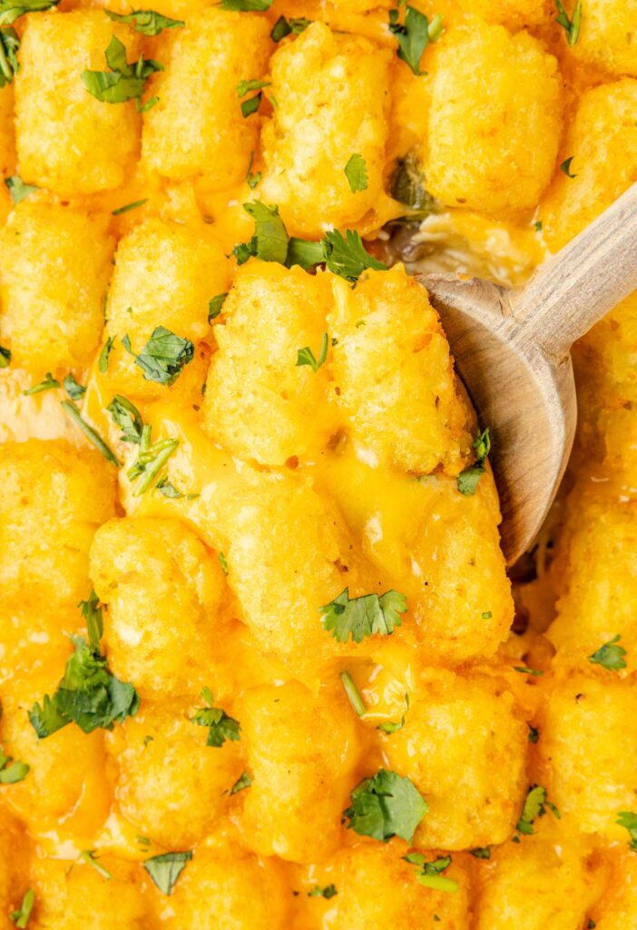 Tater tot casserole with a wooden spoon in it.