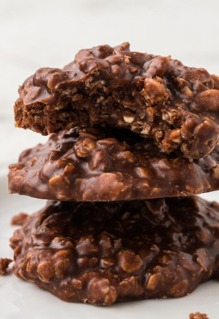 Stack of three no bake cookies with the top one having a bite taken out of it