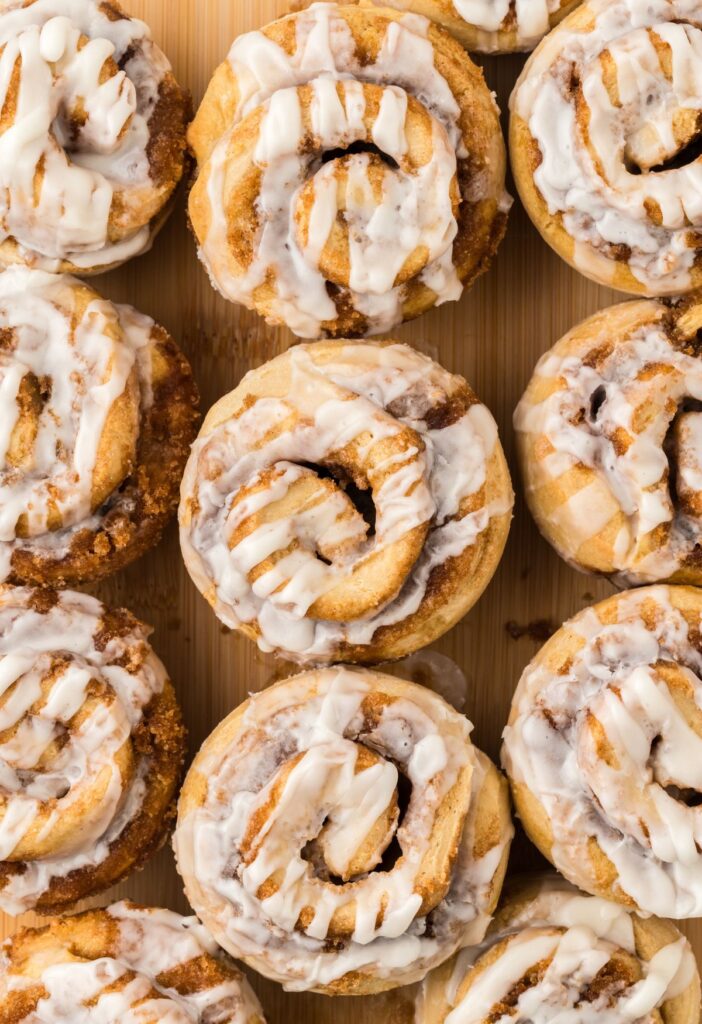 Top view of cinnamon roll muffins on a wooden cutting board.