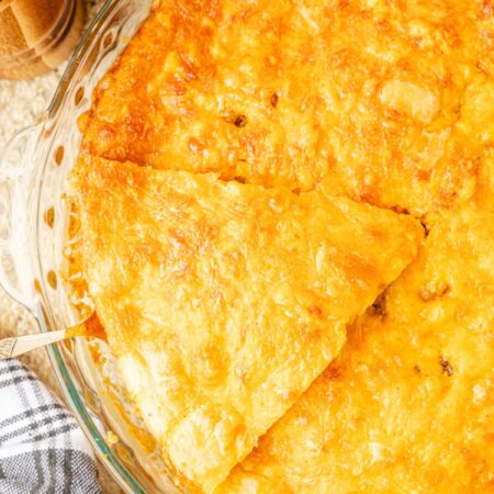 Hamburger pie baked in a pie plate with serving spatula.