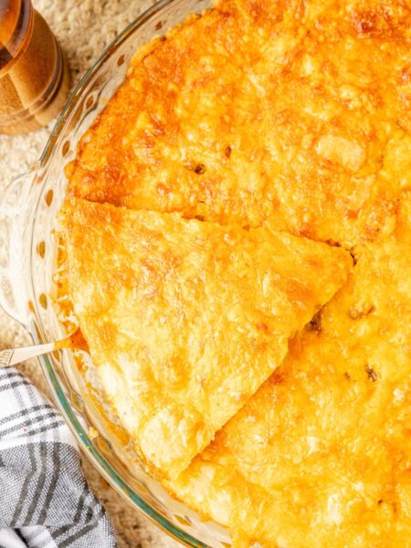 Hamburger pie baked in a pie plate with serving spatula.