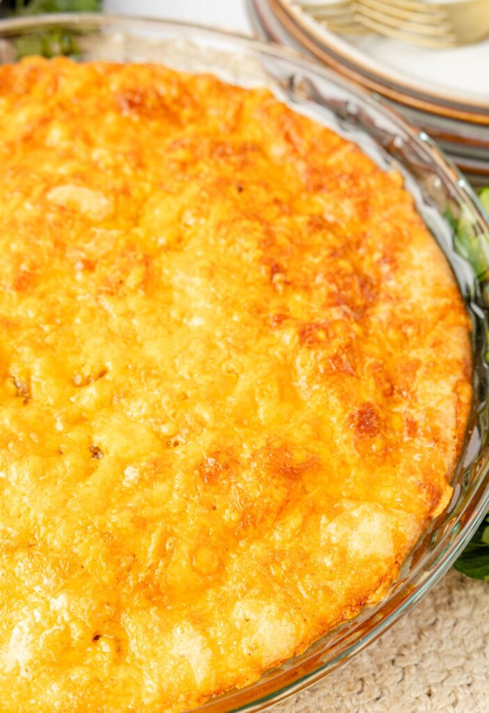 Baked hamburger pie inside a glass pie plate.