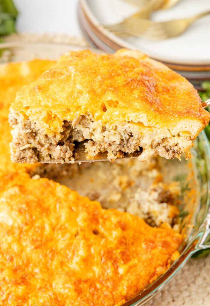 Slice of hamburger pie above the pie in the pie plate.