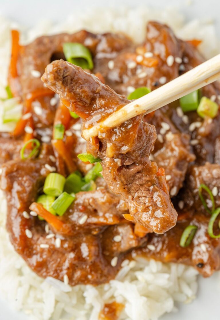 Chopsticks holding a piece of the beef