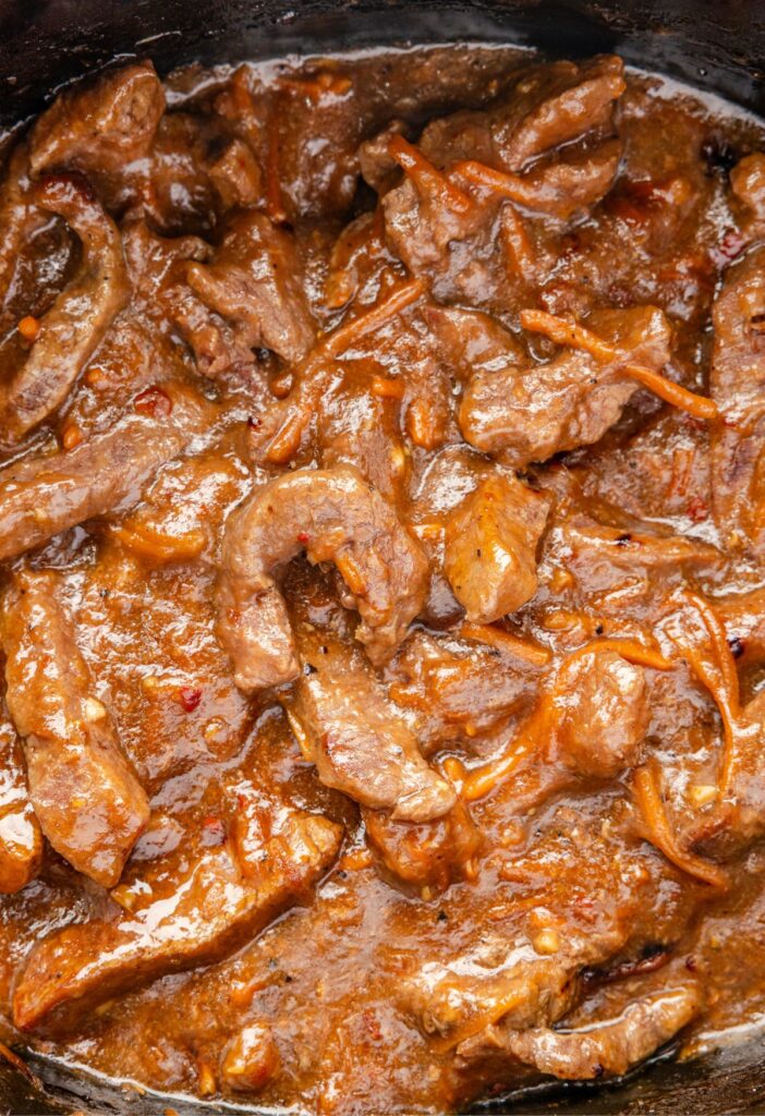 Inside of the slow cooker with the cooked Mongolian beef