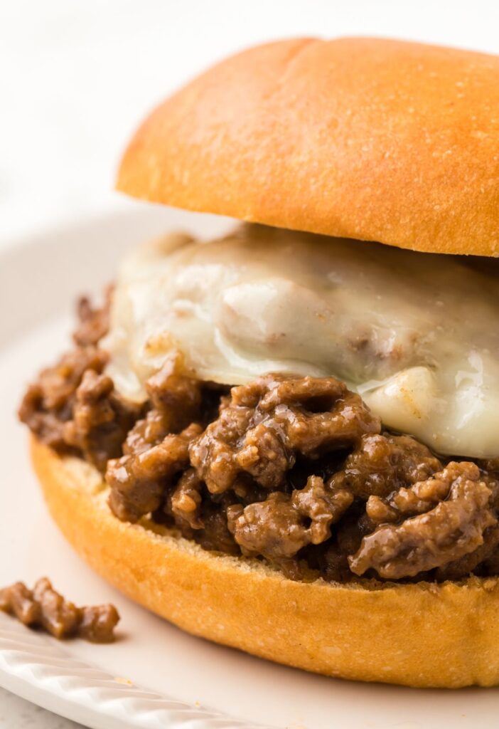 A sloppy Joe up close with melted cheese and ground beef French onion filling.