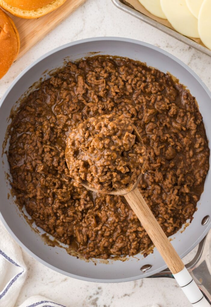 Top view of the sloppy Joe filling inside a skillet pan with a serving spoon.