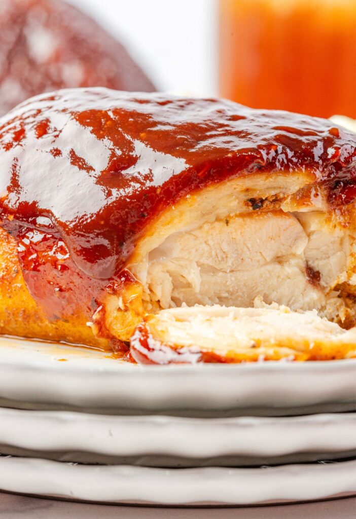 A chicken thigh cut open sitting on a stack of plates.