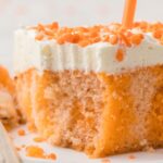 A slice of the poke cake with a fork bite taken out of it.