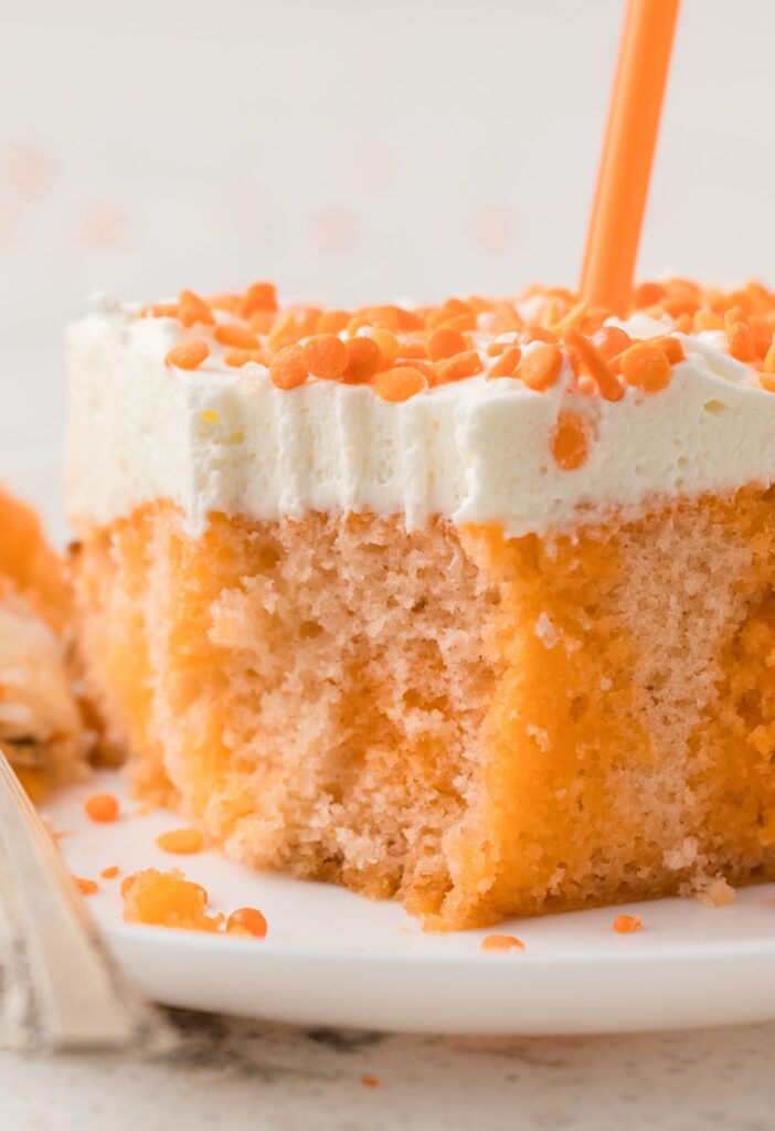 A slice of the poke cake with a fork bite taken out of it.