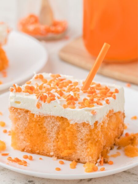 A slice of poke cake with orange jello and orange crush soda, and a cake mix.