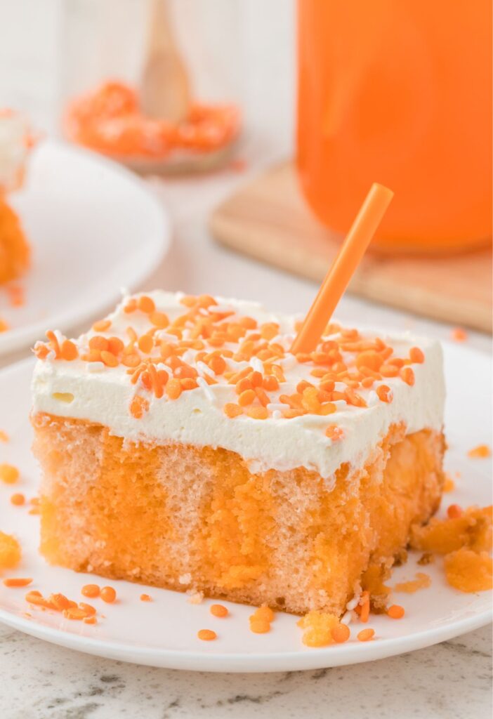 A slice of poke cake with orange jello and orange crush soda, and a cake mix.