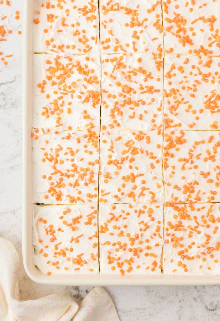 Top view of the baked poke cake with whipped cream.