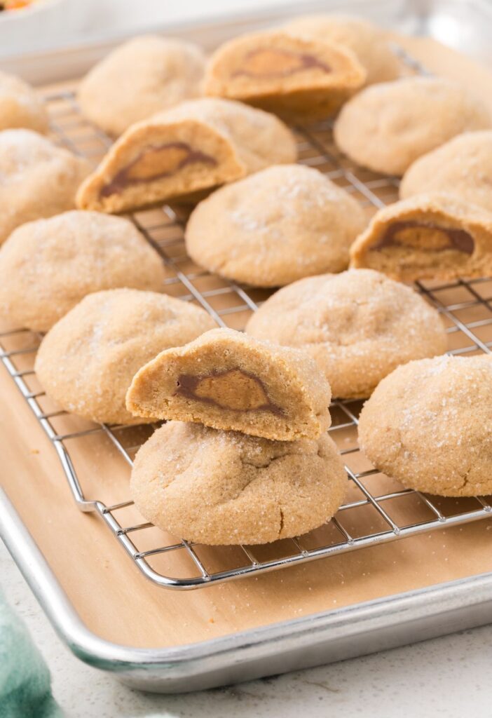 Stack of cookies with other cookies cooling in the background.