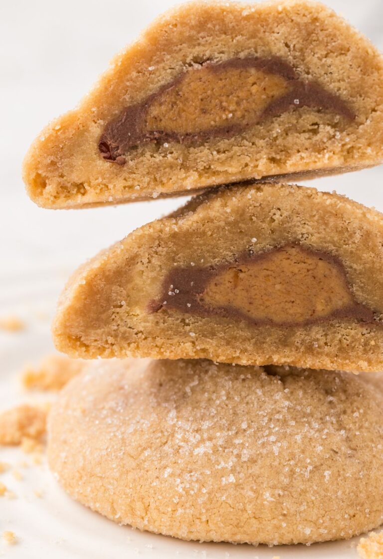 Stack of cookies with one of them cut in half so you can see the inside.