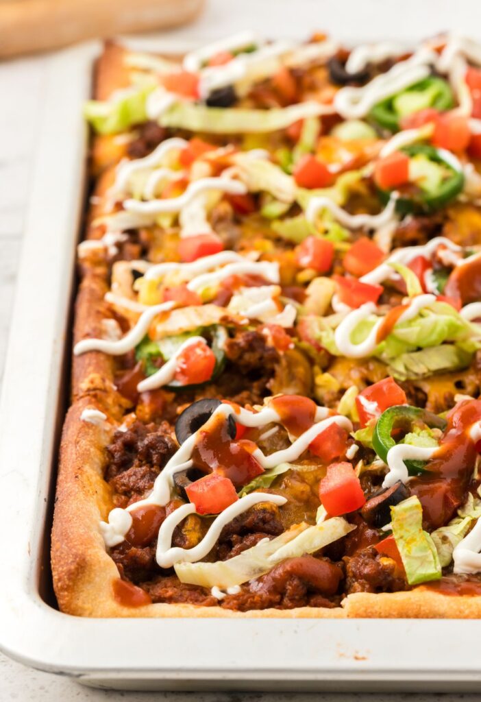 Side view of the sheet pan pizza inside the pan.