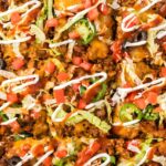 Top view up close of the baked taco pizza with taco toppings.