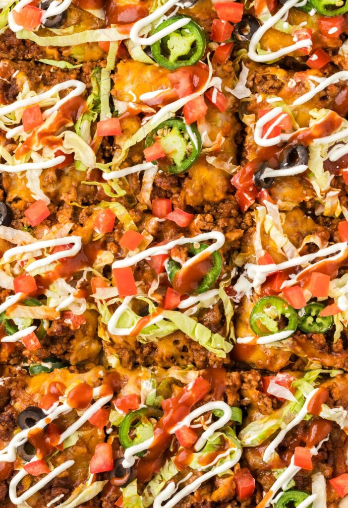 Top view up close of the baked taco pizza with taco toppings.