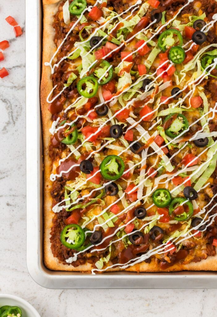 The pizza inside the sheet pan with toppings, ready to serve.