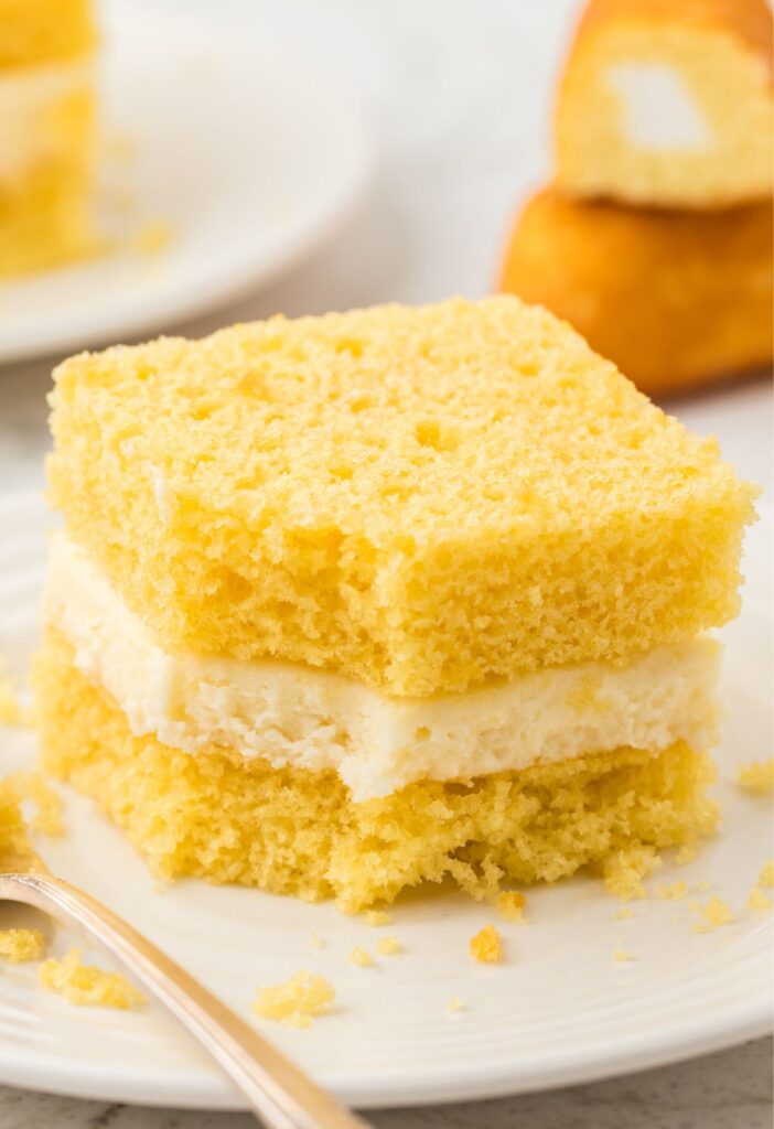 A slice of Twinkie Cake with a fork and whipped cream on top