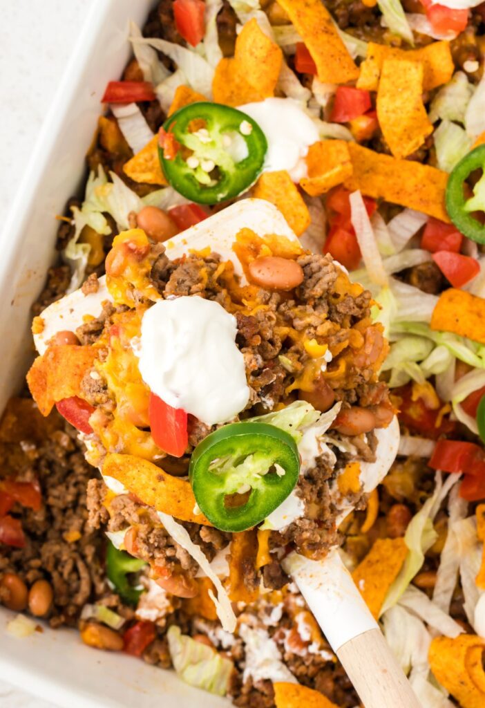 A scoop of the casserole on a white spatula up close in the picture.