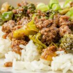 Plate of white rice with beef and broccoli on top