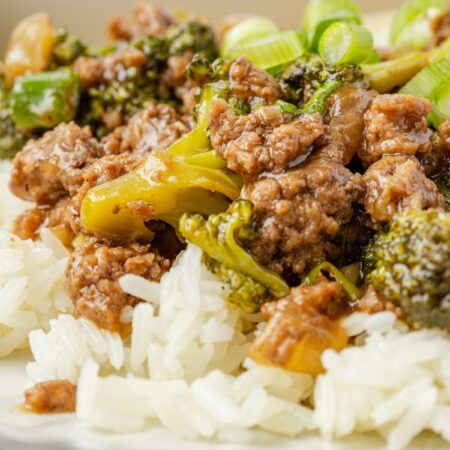Plate of white rice with beef and broccoli on top