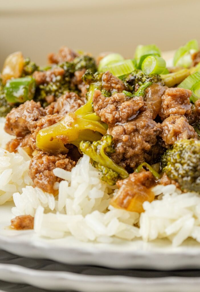 Plate of white rice with beef and broccoli on top
