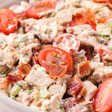 chicken salad inside a bowl with tomatoes, bacon, and chicken