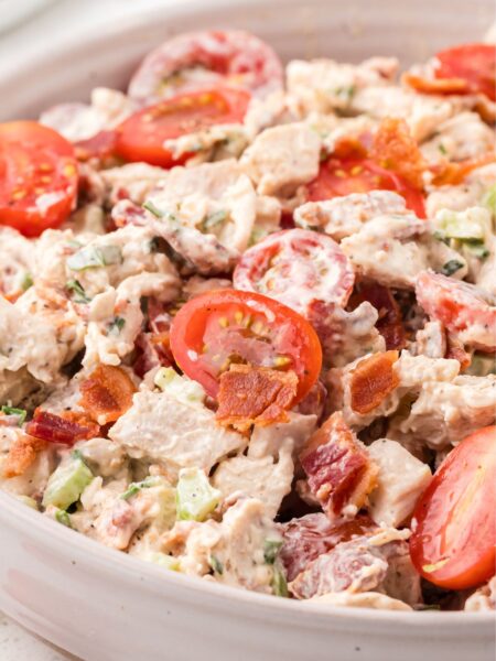 chicken salad inside a bowl with tomatoes, bacon, and chicken