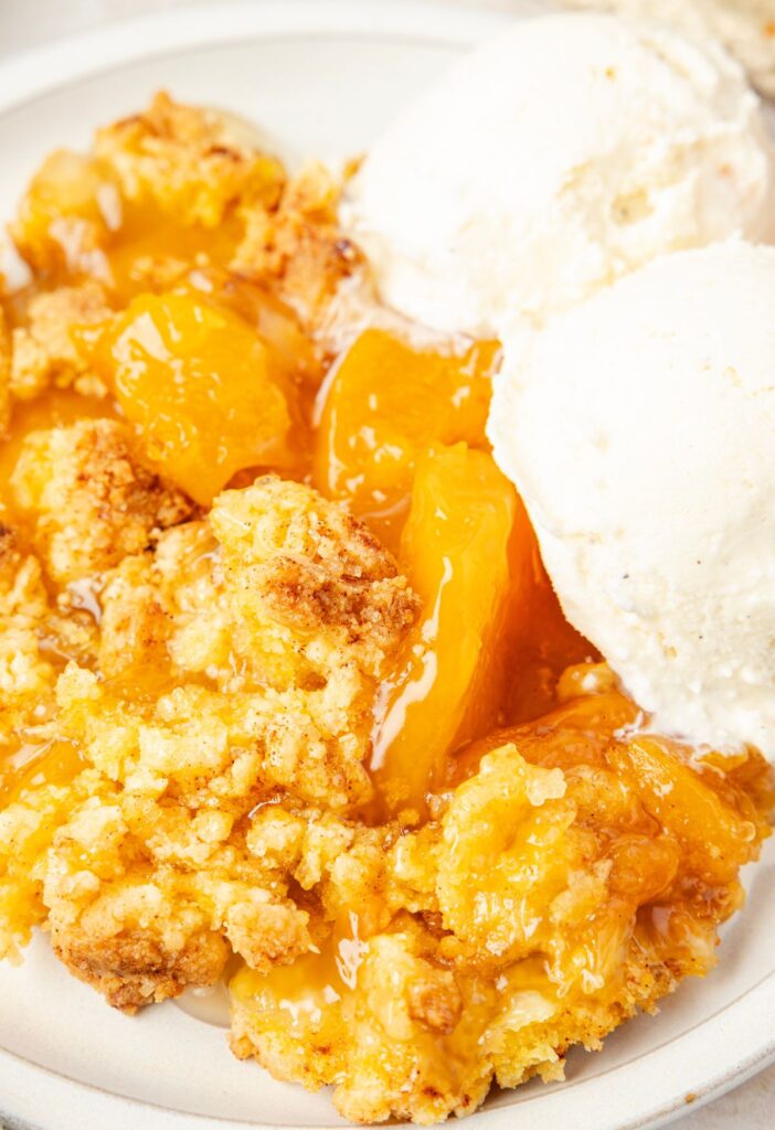 serving of the cake batter peach cobbler with ice cream on it