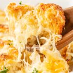 Close up of a scoop scooping up some of the biscuit casserole with cheese