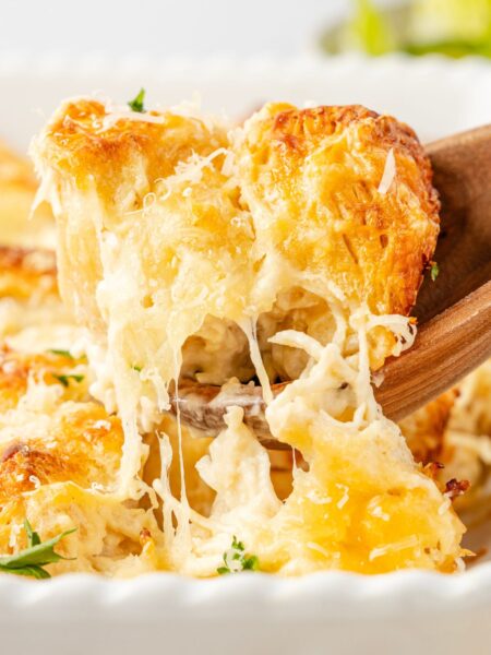 Close up of a scoop scooping up some of the biscuit casserole with cheese