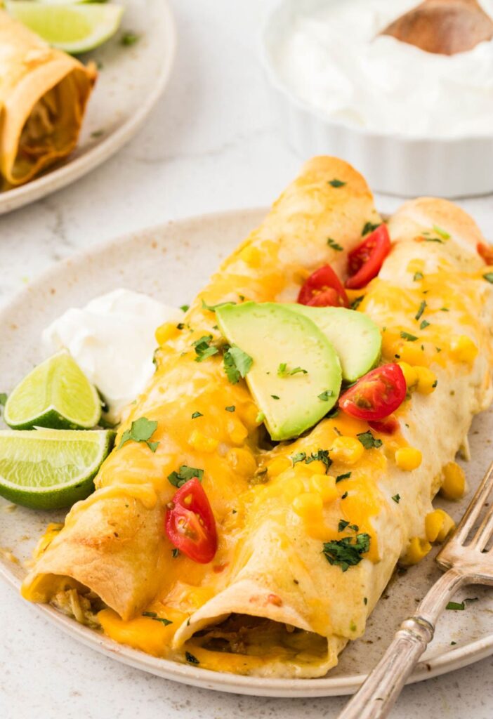 A plate of two enchiladas with a fork