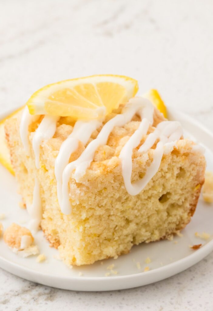 A slice of the lemon coffee cake with a crumble and glaze on top.